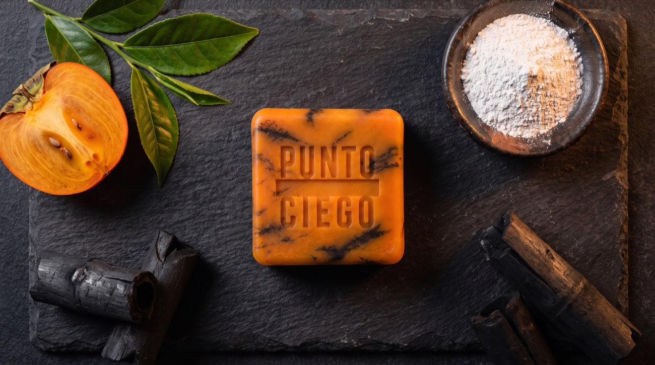 La barra Punto Ciego rodeada de sus tres frentes: té verde con caqui, óxido de zinc y carbón de bambú